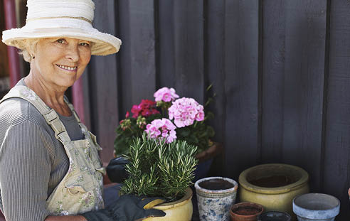 Senior woman planting flowers in a pot